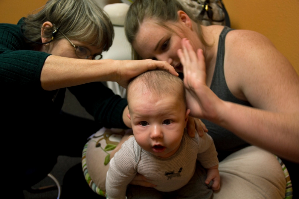 Dr. Mary Johnson and Chandler Ignatowicz examine Martin Williams’ head at his weekly check up on Nov. 4, 2014 at Phoenix Children’s Hospital in Phoenix. Williams developed rashes on the back of his head due to the helmet. (Photo by Alexis Macklin)