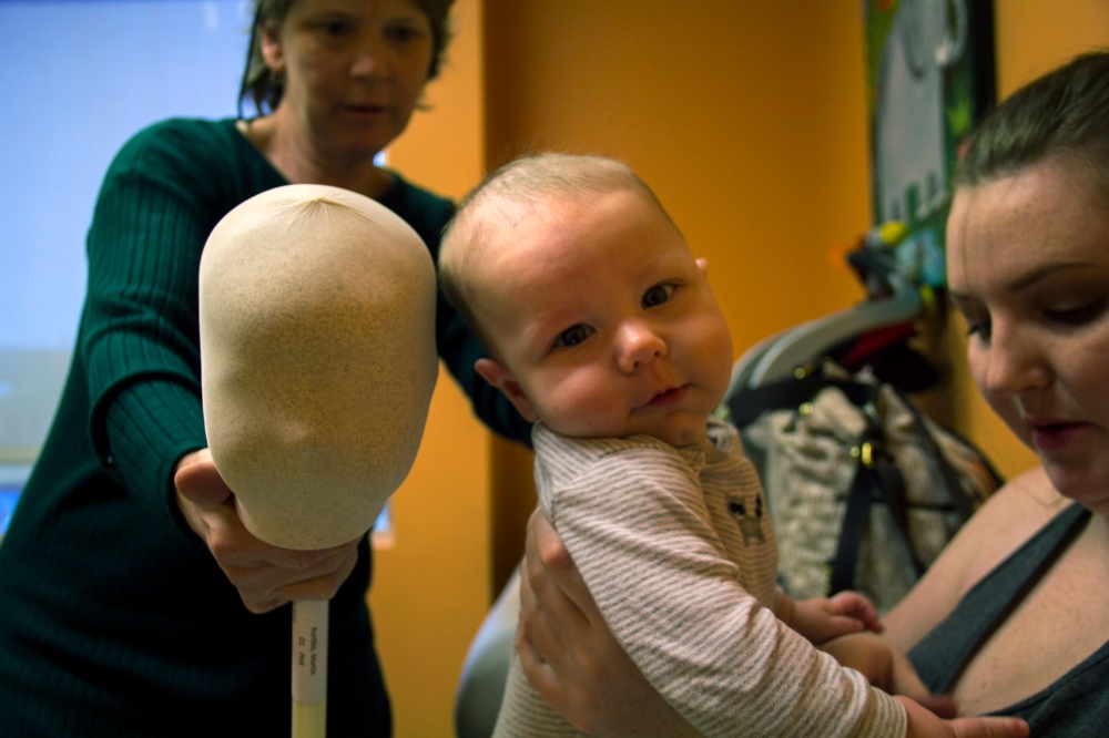 Dr. Mary Johnson examines Martin Williams’ head at his weekly check up on Nov. 4, 2014 at Phoenix Children’s Hospital in Phoenix. The dummy head is a reference point to Williams’ progress. (Photo by Alexis Macklin)